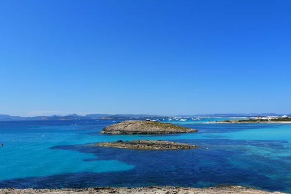 plage d'Ibiza avec des petites îles et la mer turquoise et bleu