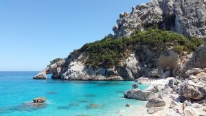 plage avec des rochers, mer bleu turquoise et une falaise blanche
